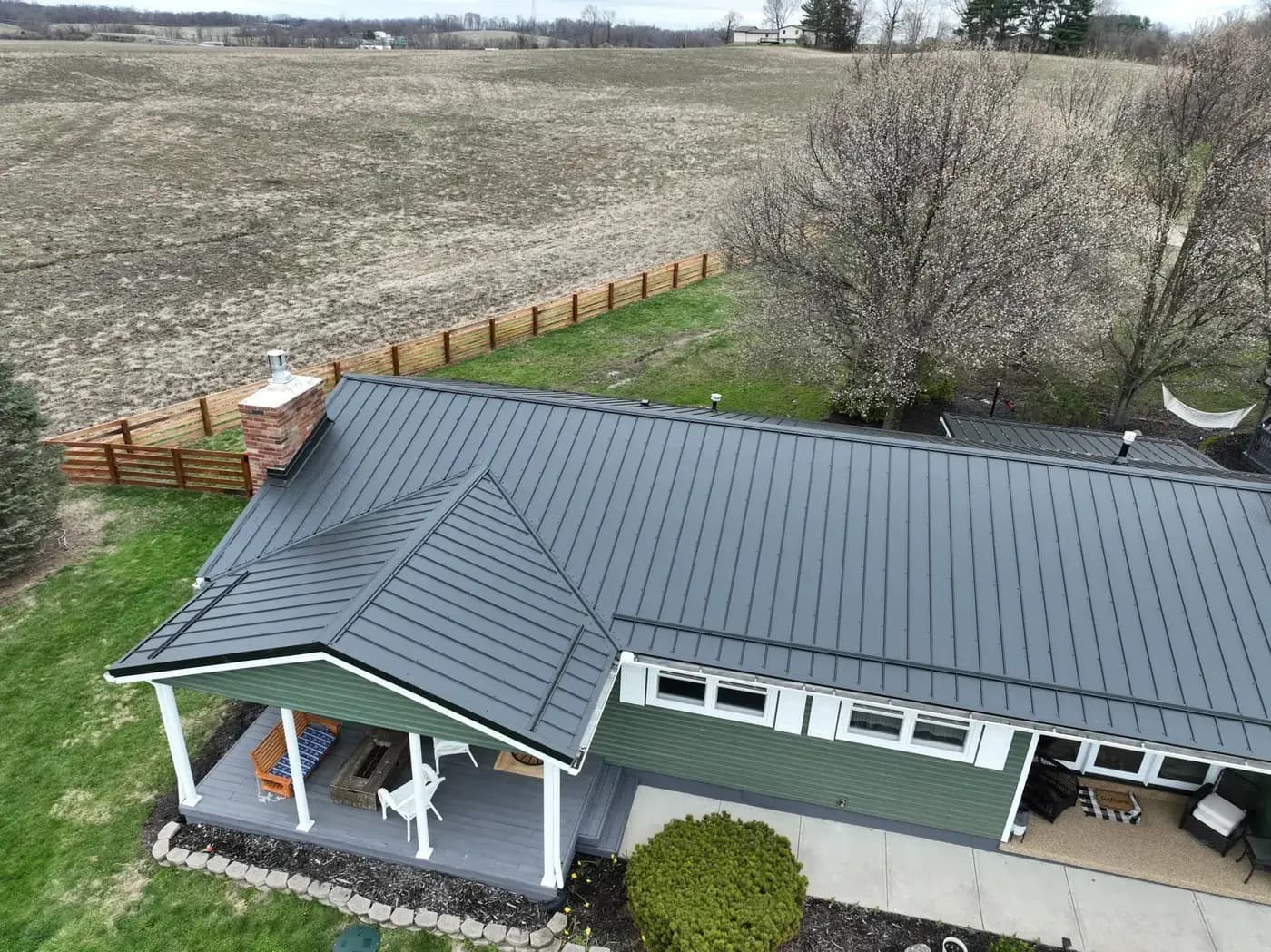 Charcoal standing-seam metal roofing across a home and connected front porch