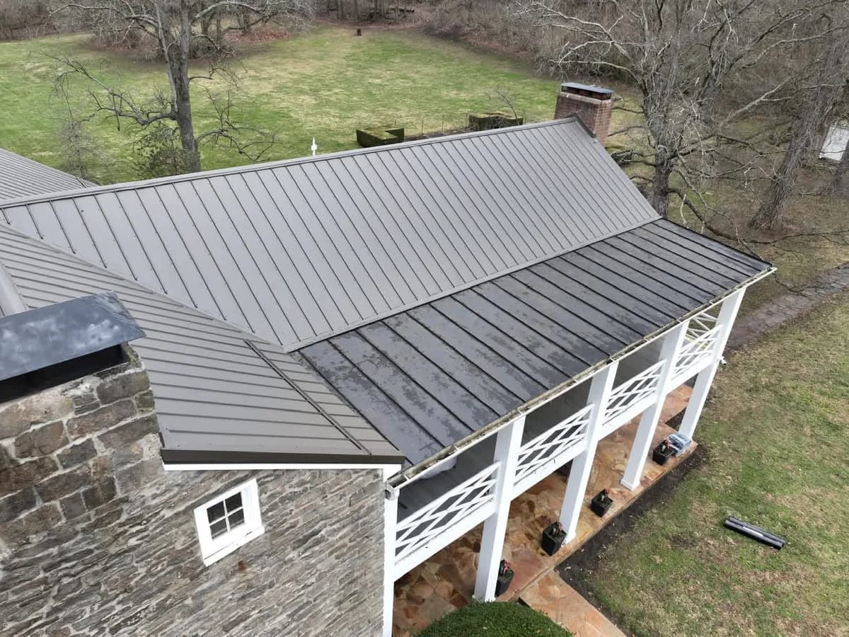 Gray standing-seam metal roof with porch and chimney details